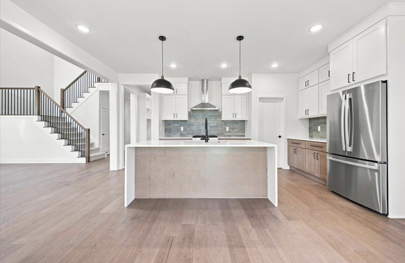 Kitchen with oversized island and two-tone cabinetry