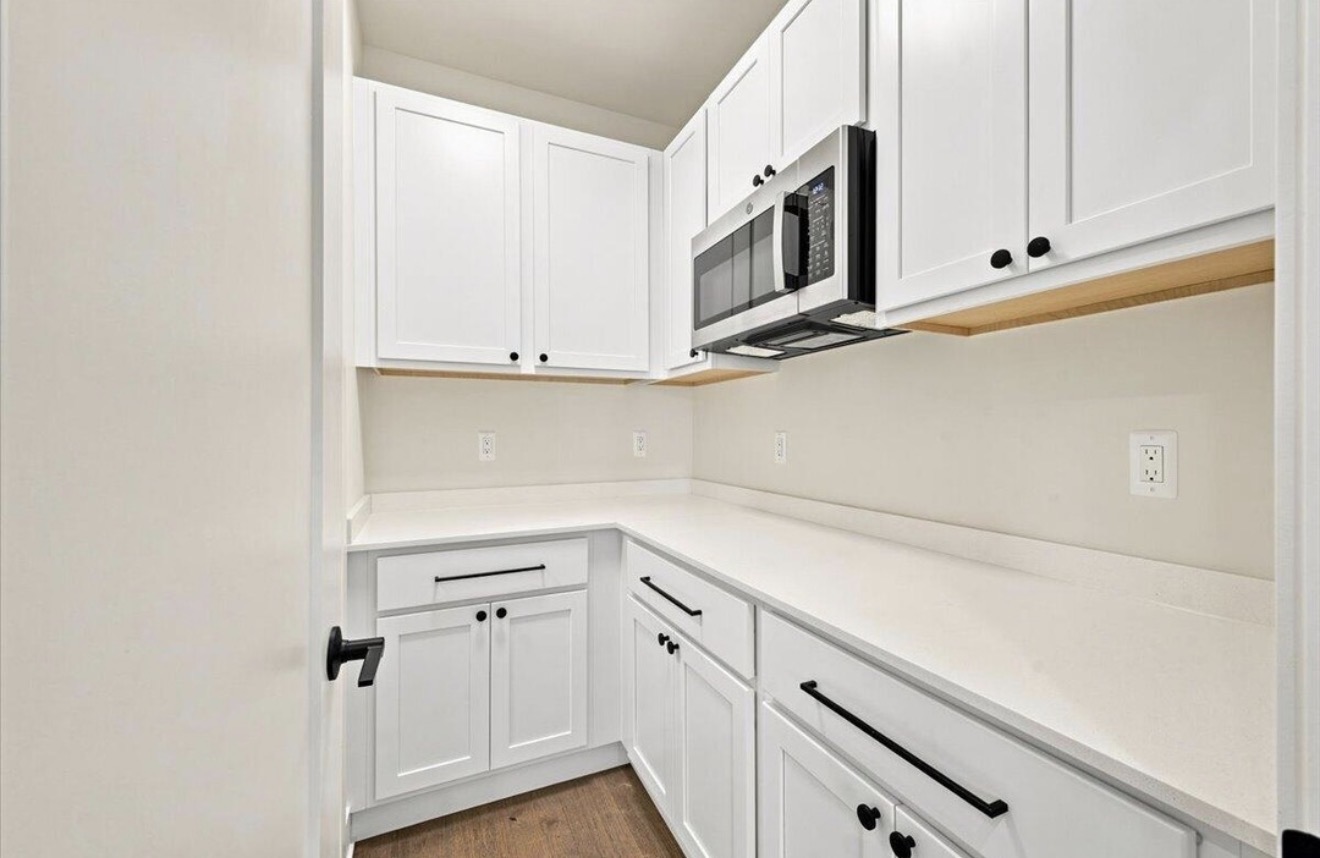 Kitchen cabinetry with walk-in pantry beyond