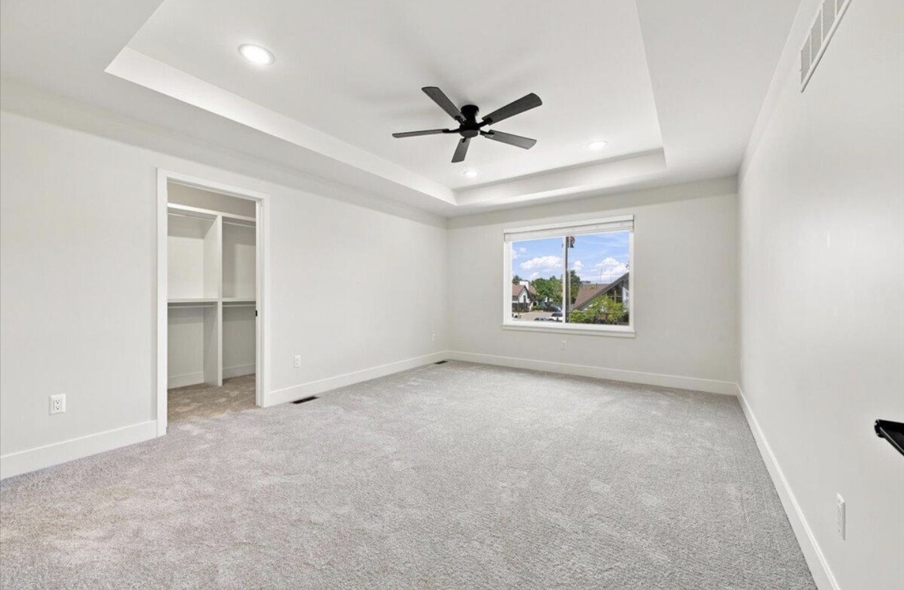 Primary bedroom with tray ceiling and walk-in closet