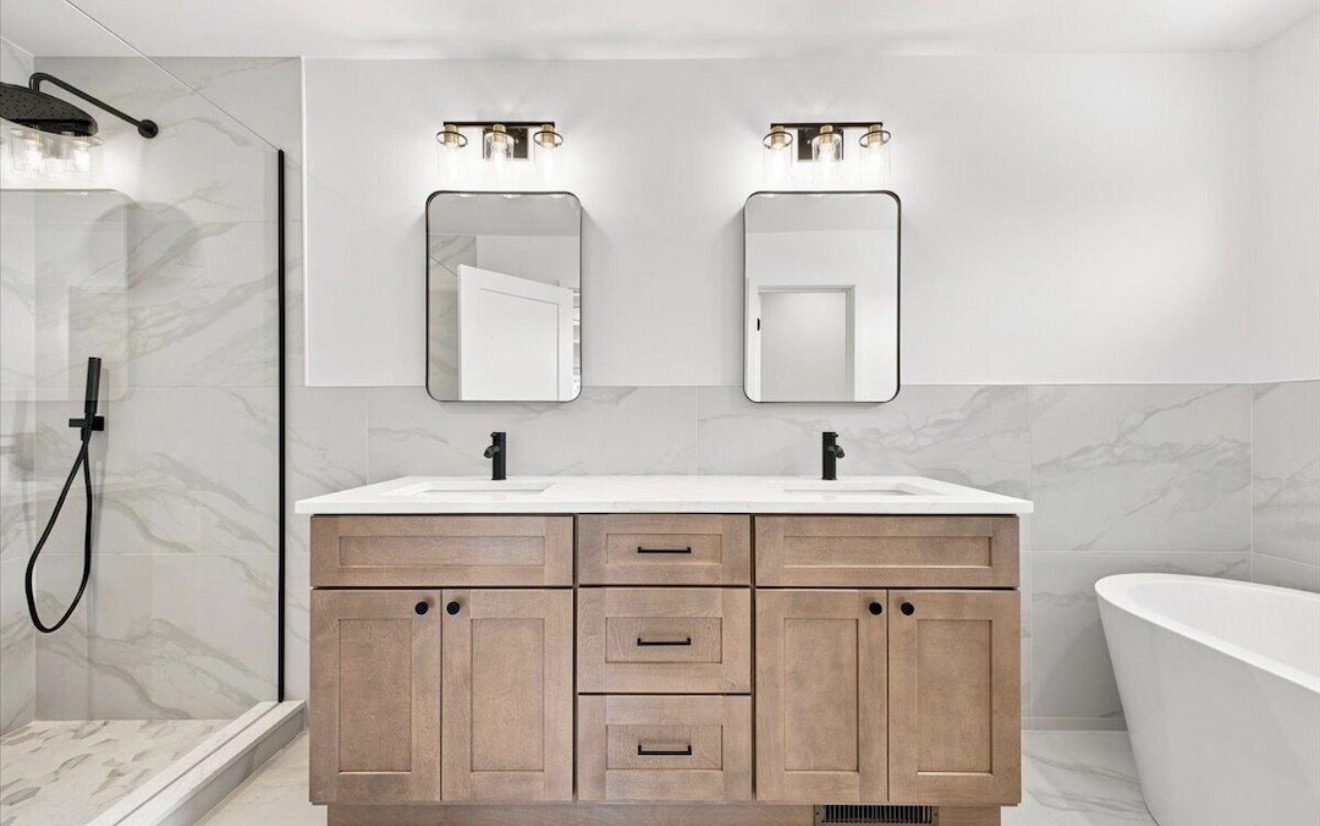 Primary bathroom with double vanity, glass shower and soaking tub
