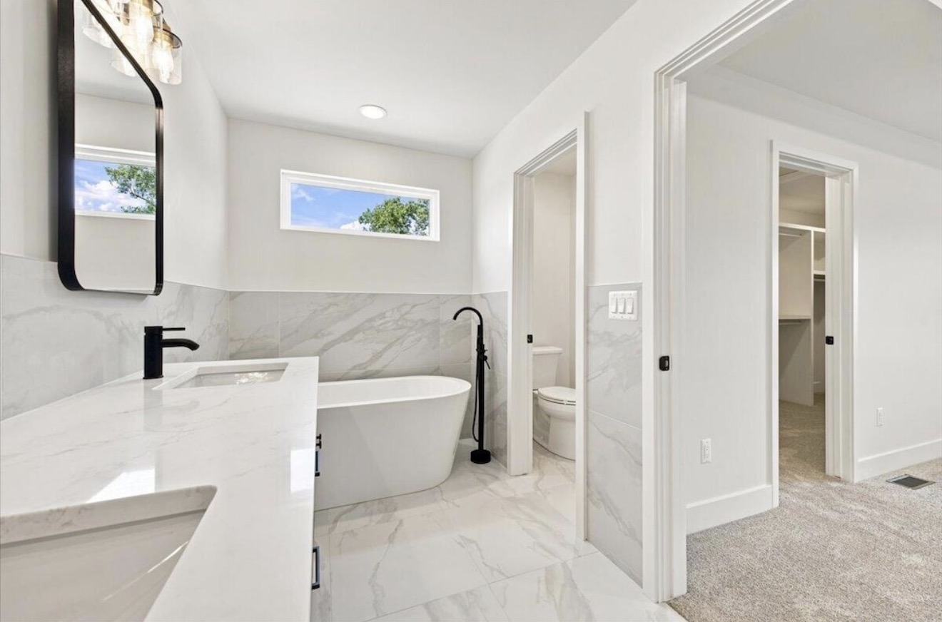 Primary bathroom with soaking tub and adjoining walk-in closet