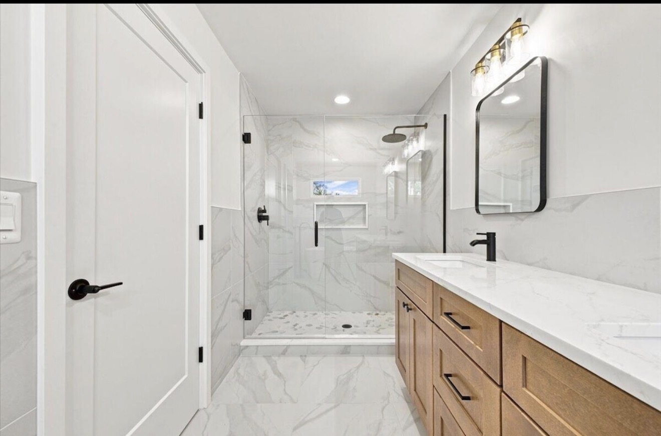 Bathroom with wood vanity and glass-enclosed shower